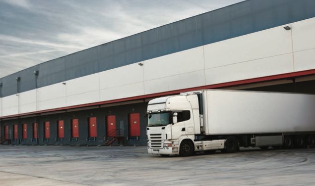imagem de um galpão logístico com um caminhão estacionado